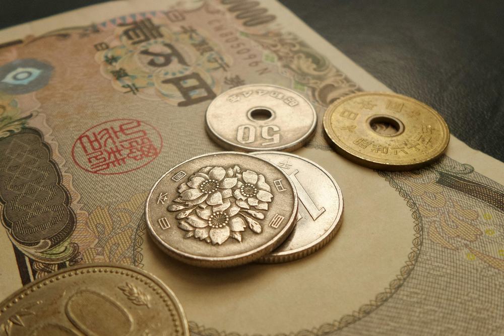 一万円札の上に置かれた硬貨