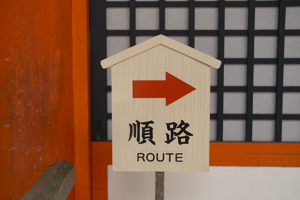 「順路 ROUTE」と書かれた矢印付きの木の案内札