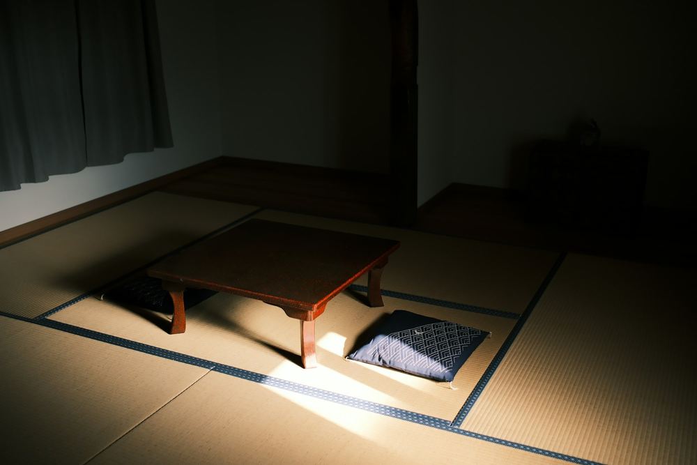 光の差す誰もいない和室。座卓と座布団が整えられている