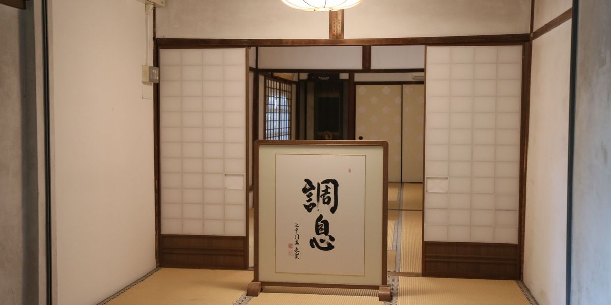 An open doorway with paper screens looking out over rooftops and hills