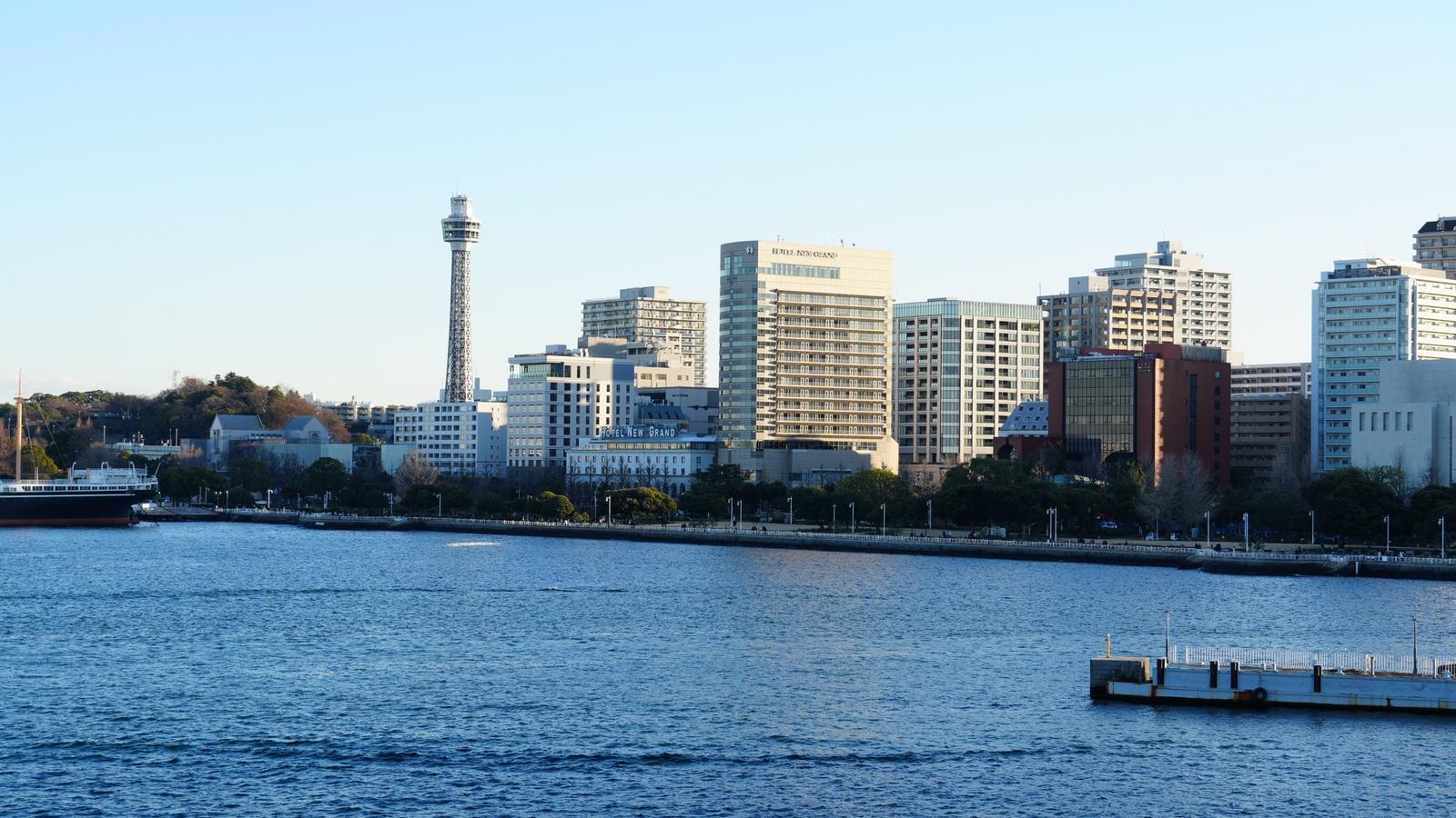Le front de mer de Yokohama au parc Yamashita, avec la Marine Tower et l’Hotel New Grand au-dessus de l’eau, sous un ciel clair