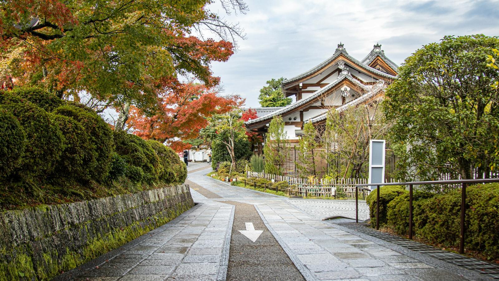 穿過秋日樹木、通往寺院屋頂的寧靜步道