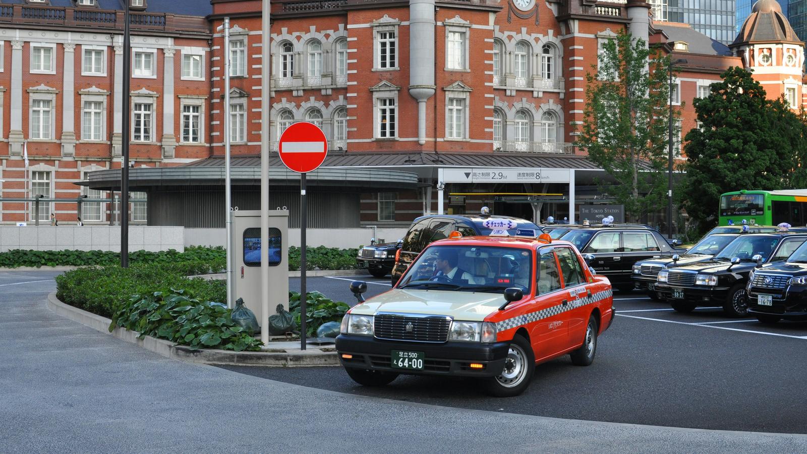 A taxi waiting in front of the red brick Marunouchi building of Tokyo Station