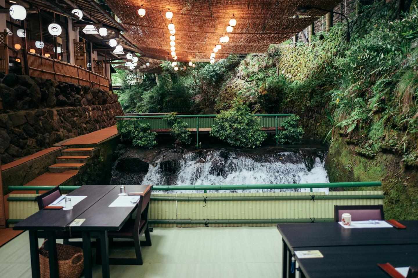 Tables on a kawadoko platform over a mountain stream at Kibune, beside a small waterfall
