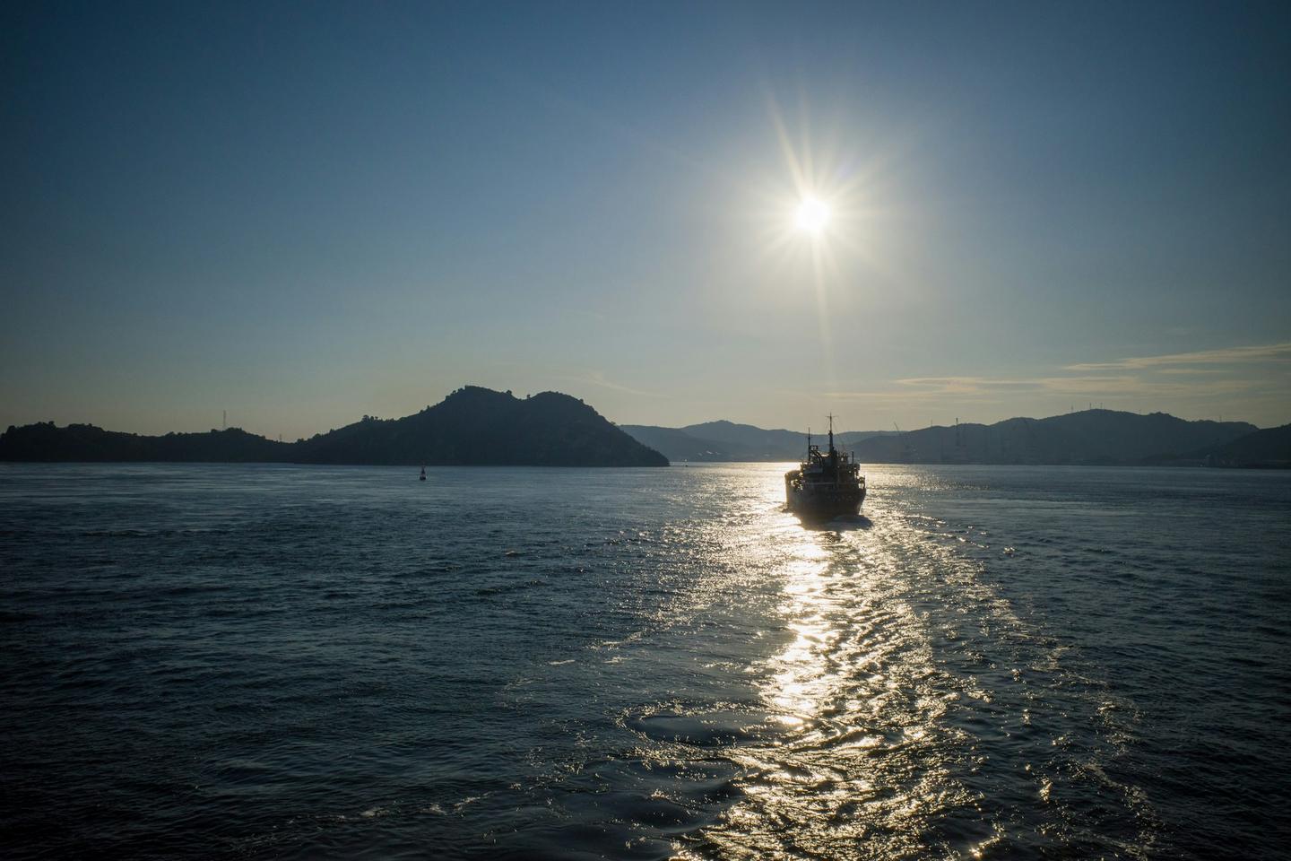 夕陽下穿行於島嶼之間、橫渡瀨戶內海的船