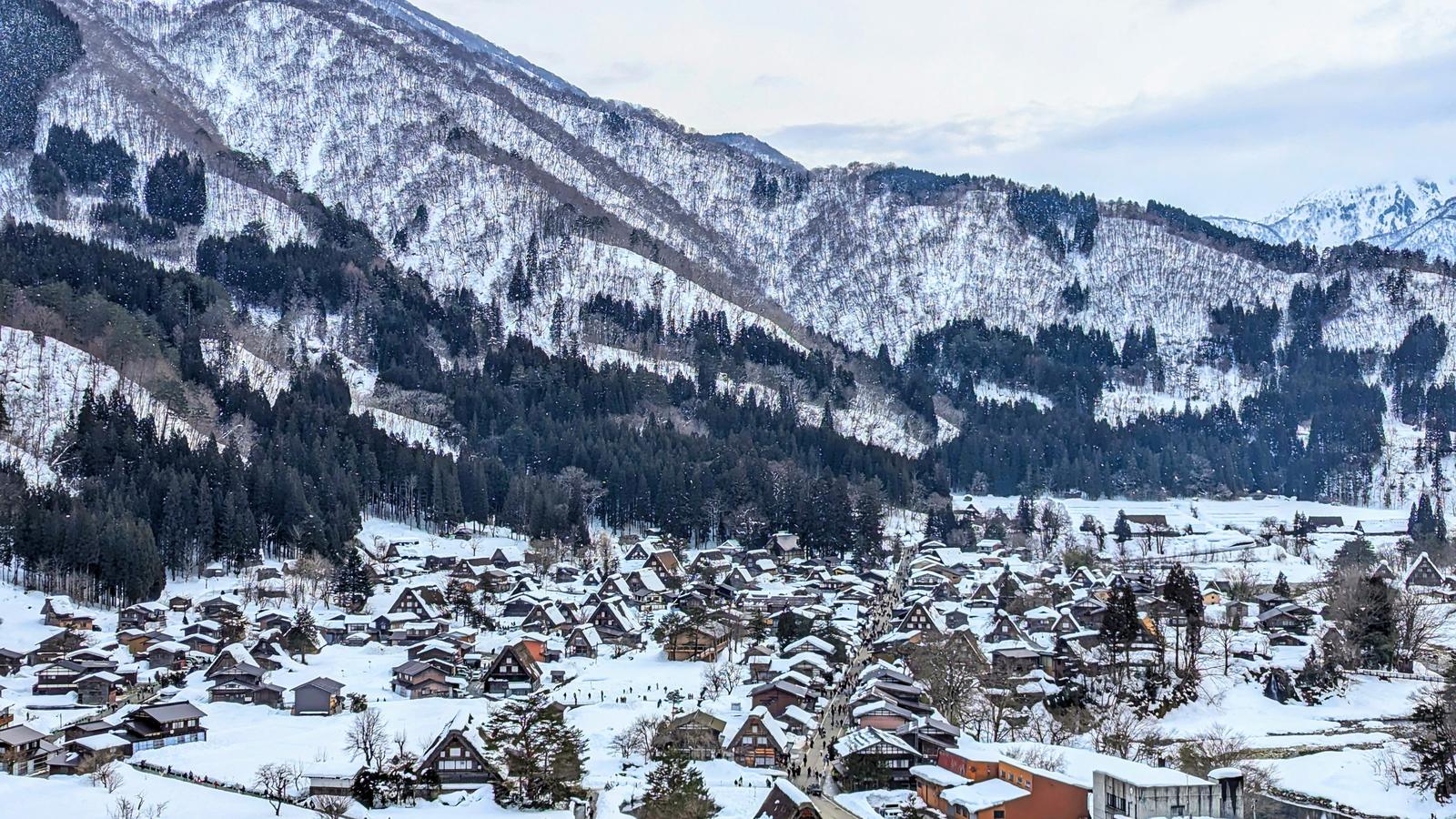Shirakawa-go under snow seen from the Ogimachi Castle ruins, the thatched farmhouses spread along the valley floor below the mountains