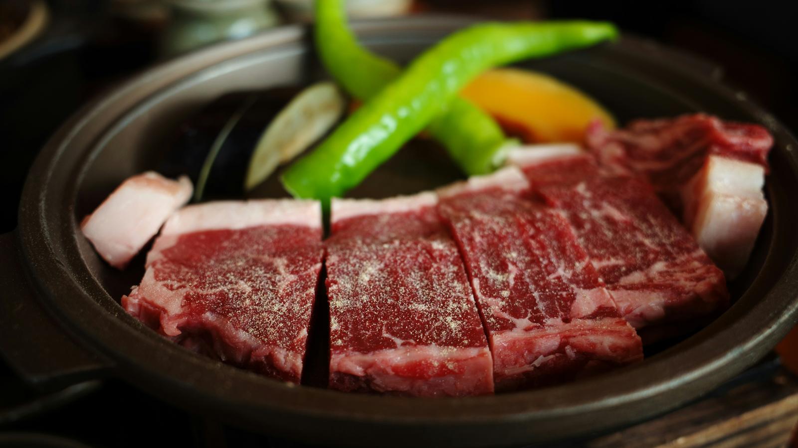 Thin slices of raw marbled beef arranged with vegetables in a bowl, ready for a hot pot in Kyoto