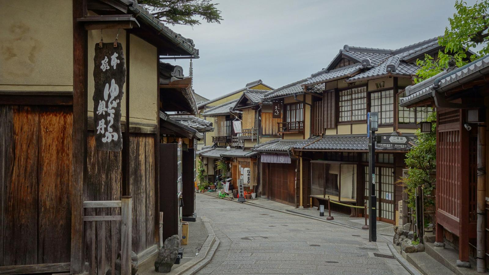 An empty lane of old wooden townhouses in Kyoto in the early morning