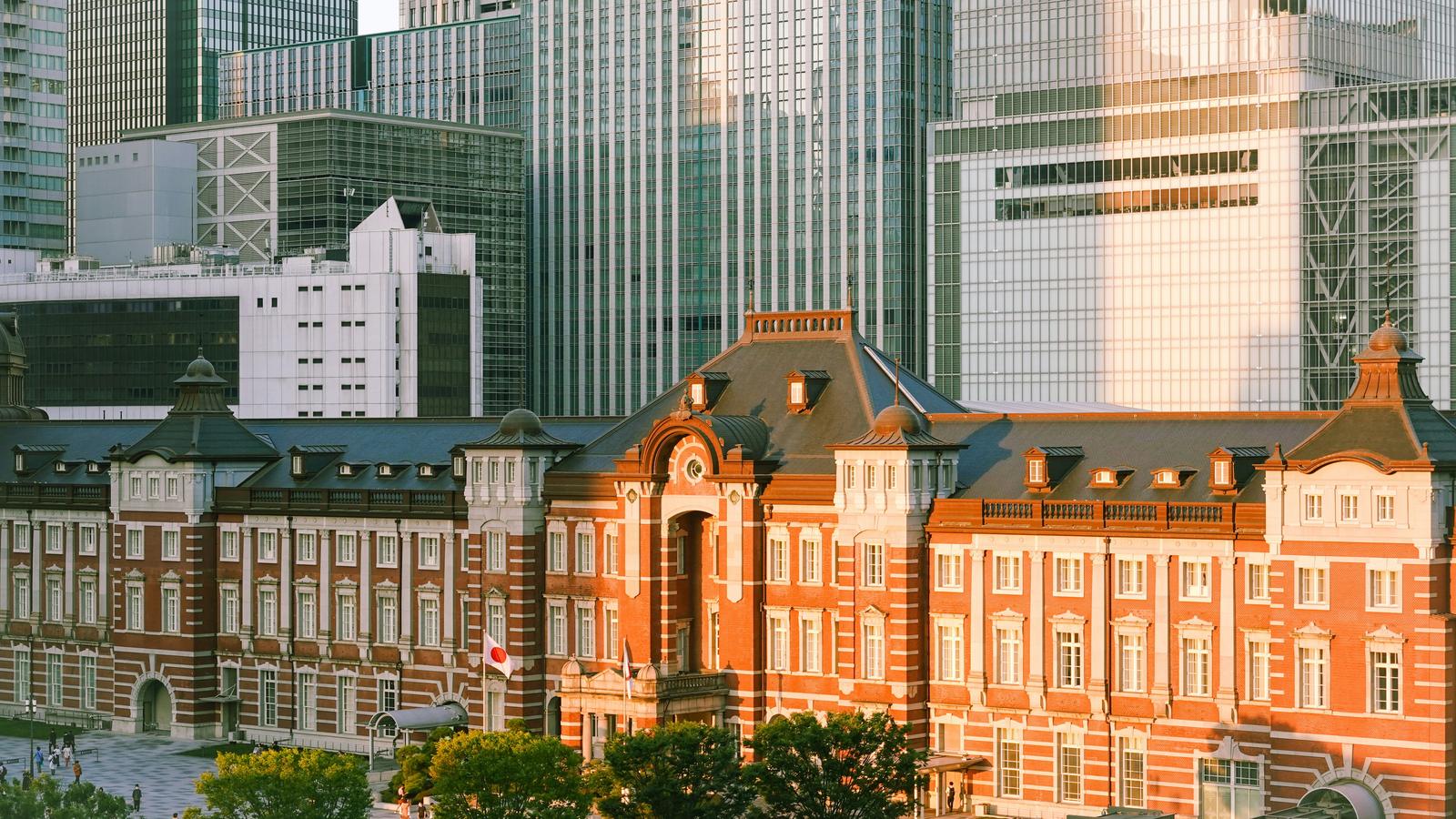 The red brick Marunouchi building of Tokyo Station below the glass towers of Marunouchi