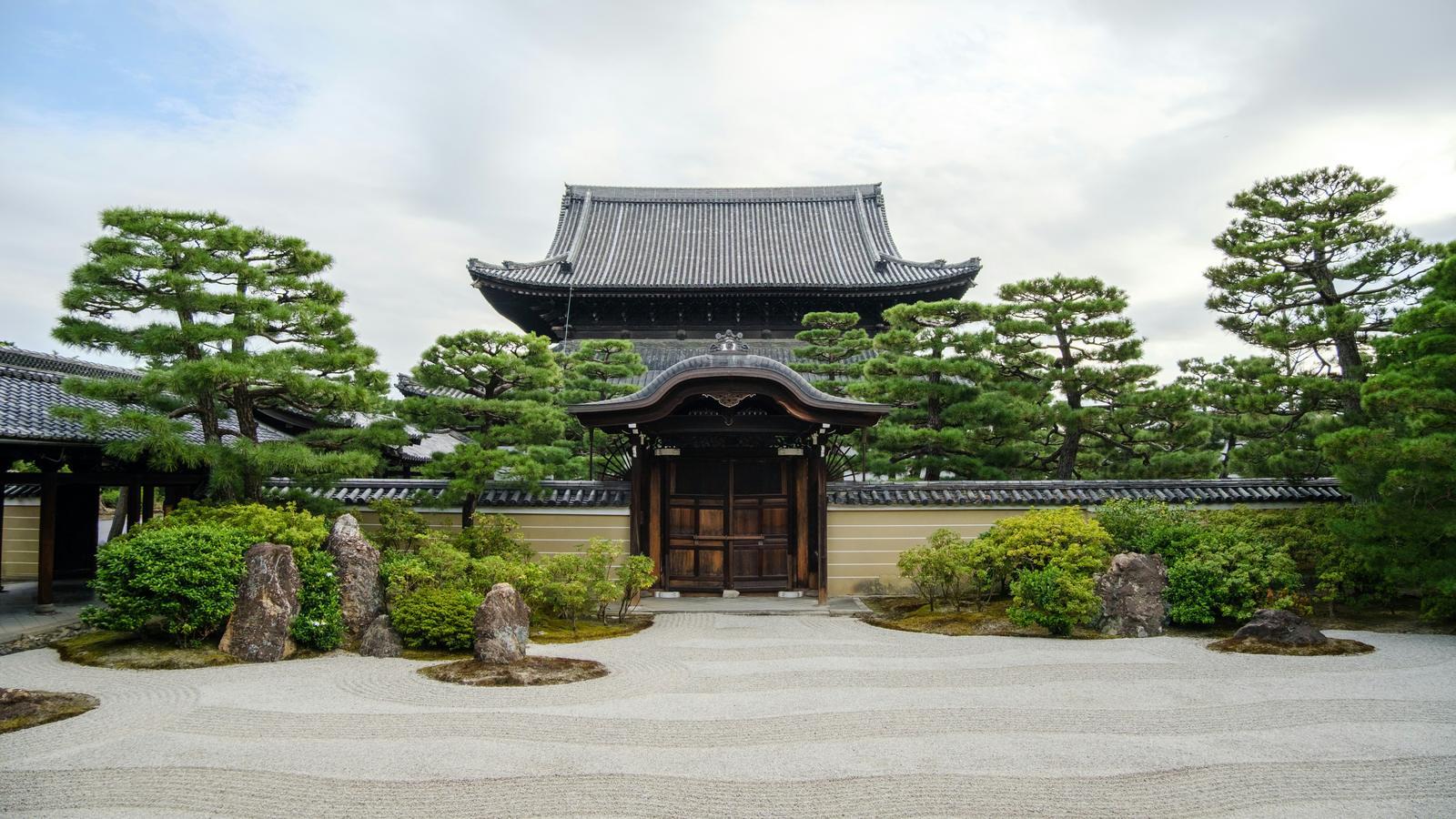 Raked gravel garden and a temple gate among pines at Kennin-ji in Kyoto