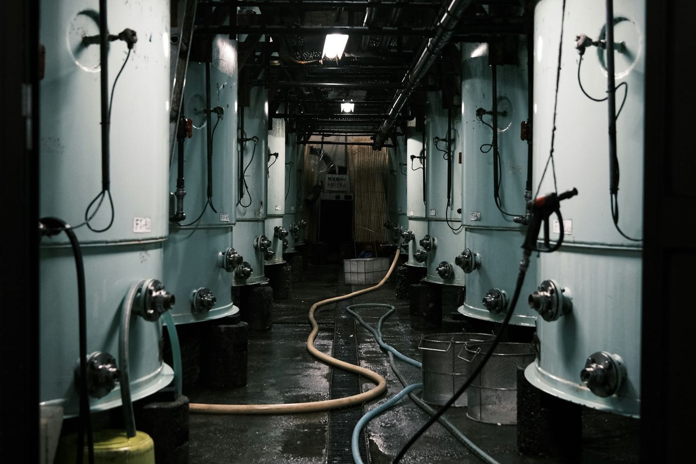 Steel tanks in a dim brewery room