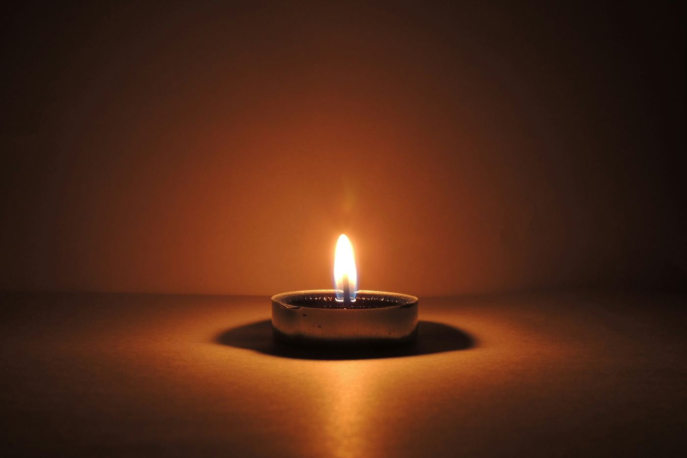 A single candle burning in a dark room
