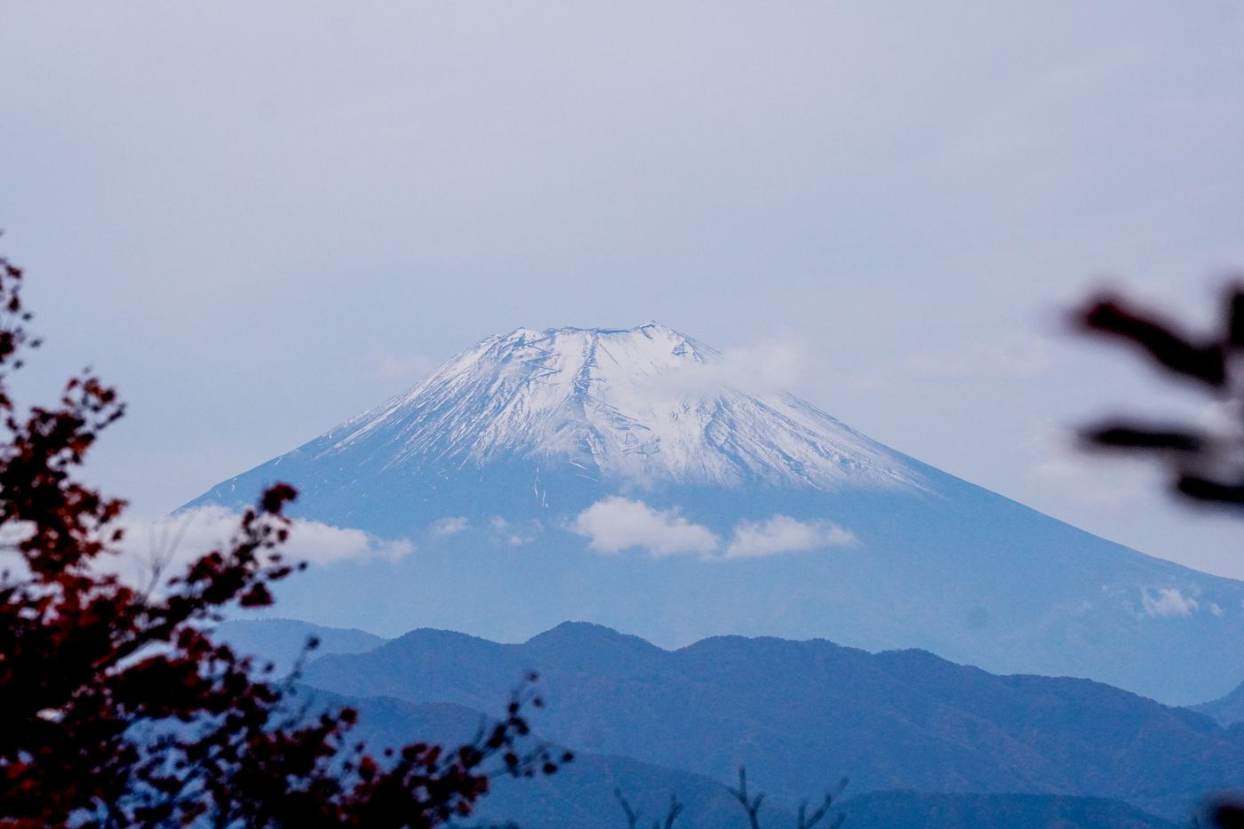 Snow-capped Mt. Fuji above blue ridges