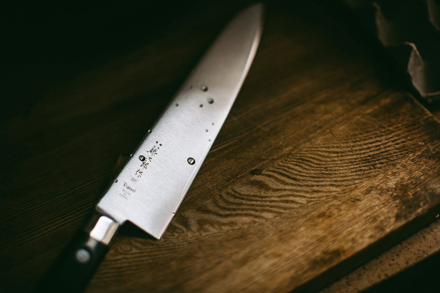 A Japanese kitchen knife on a dark wooden surface