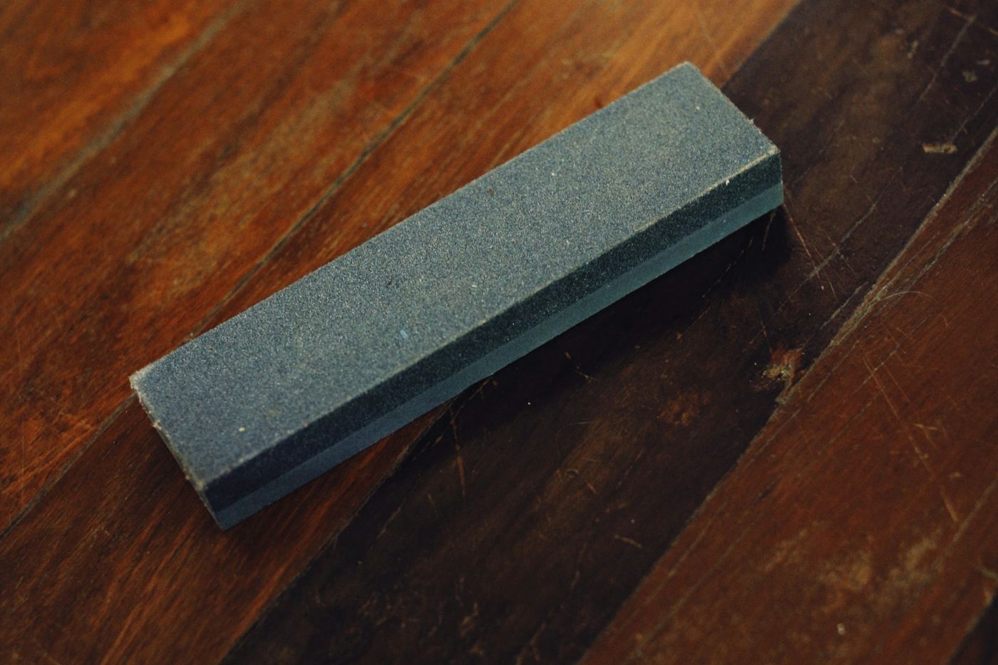 A whetstone on a dark wooden floor