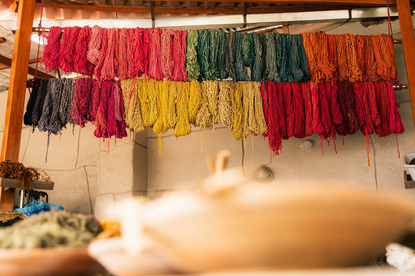 Skeins of dyed yarn hanging to dry on racks