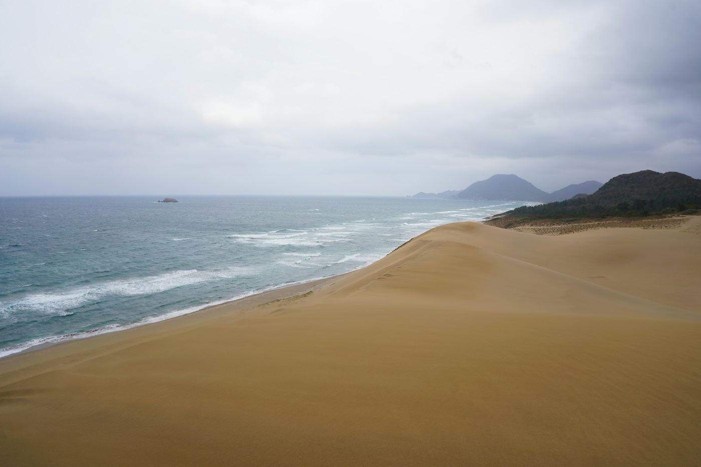 The Tottori Sand Dunes running down to the Sea of Japan under a grey sky